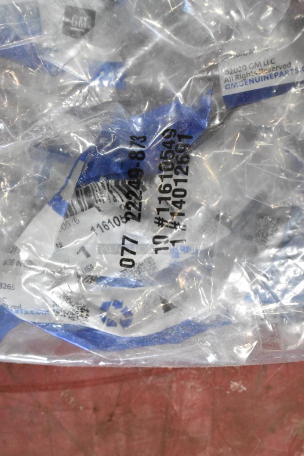 Bag with GM Genuine Parts labels showing codes and part numbers. Includes various items like ACDelco gear oil bottles.
