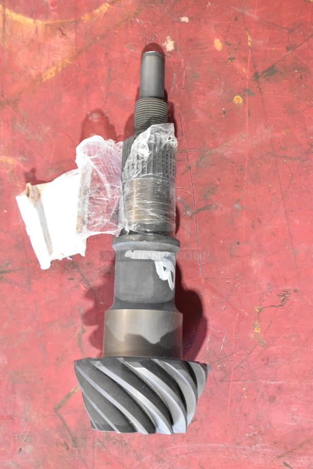 ACDelco gear part wrapped in plastic on a red surface, showing metal teeth and threaded section, appears unused.