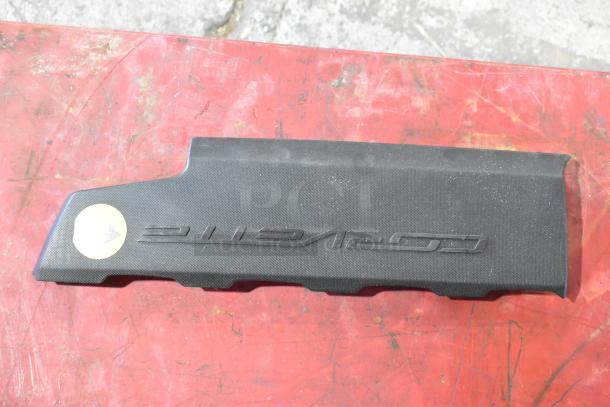 Black automotive emblem panel, textured finish, with embossed "Z71 Off Road" text, on a red distressed background.