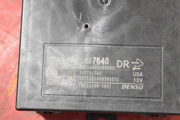 Close-up of a Denso automotive component with label showing model 1350 7640, 12V, made in USA. Light wear visible.