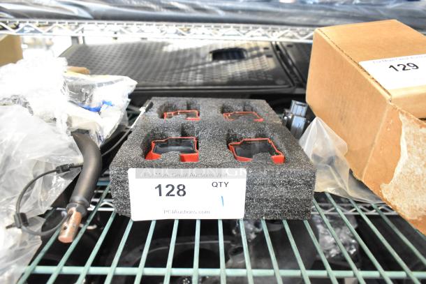 Lot of 4 red and black pieces in foam packaging, labeled "128 QTY 1" on shelf, auction setting.