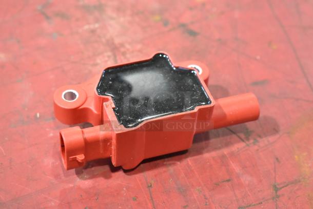 Red automotive part with a glossy black top, featuring a circular mounting hole. Appears in used condition.