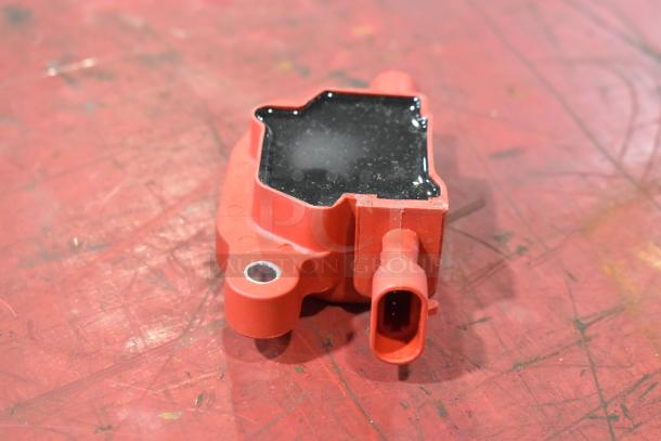 Red and black plastic component, rectangular shape, connection port, used condition; part of a lot of 4 pieces.