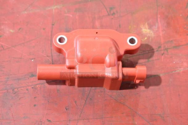 Red automotive component with two round mounting holes on a red surface, part of a lot of four pieces.