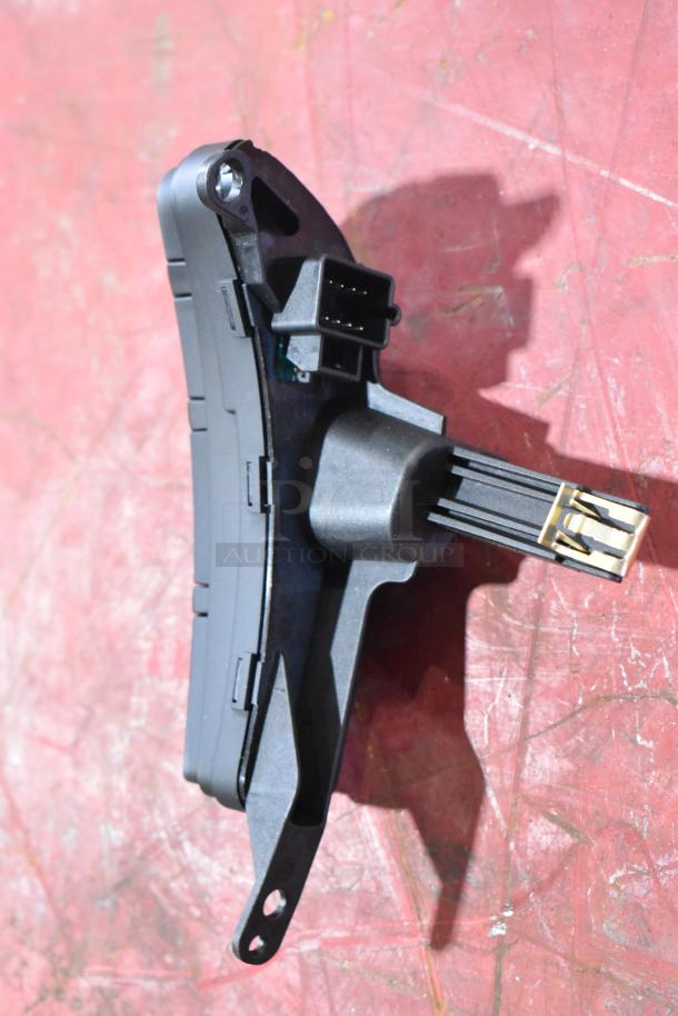 GM 20844868 switch on red surface, in good condition, with visible connectors and mounting hole, part of auction lot.