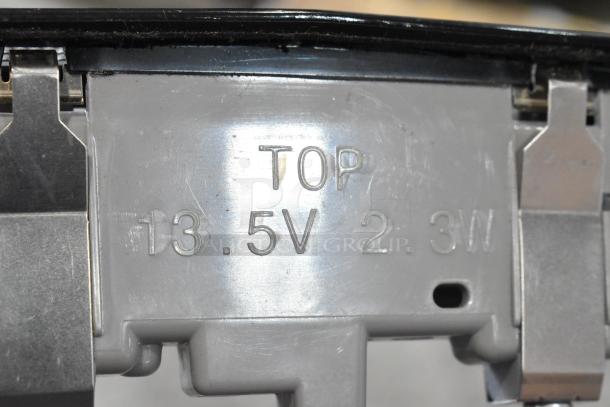 Close-up of a mechanical component marked "TOP" with values "13.5V 2.3W" visible. Part of a GM 20844868 switch.