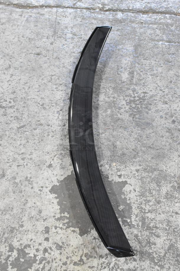 Car spoiler, model 23376474, in good condition on concrete floor, smooth black finish, aerodynamic design.