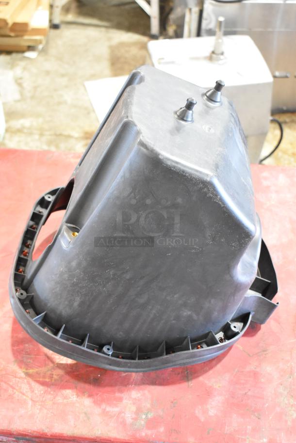 Box of parts including a large black filter housing with visible fittings, in used condition on a red surface.