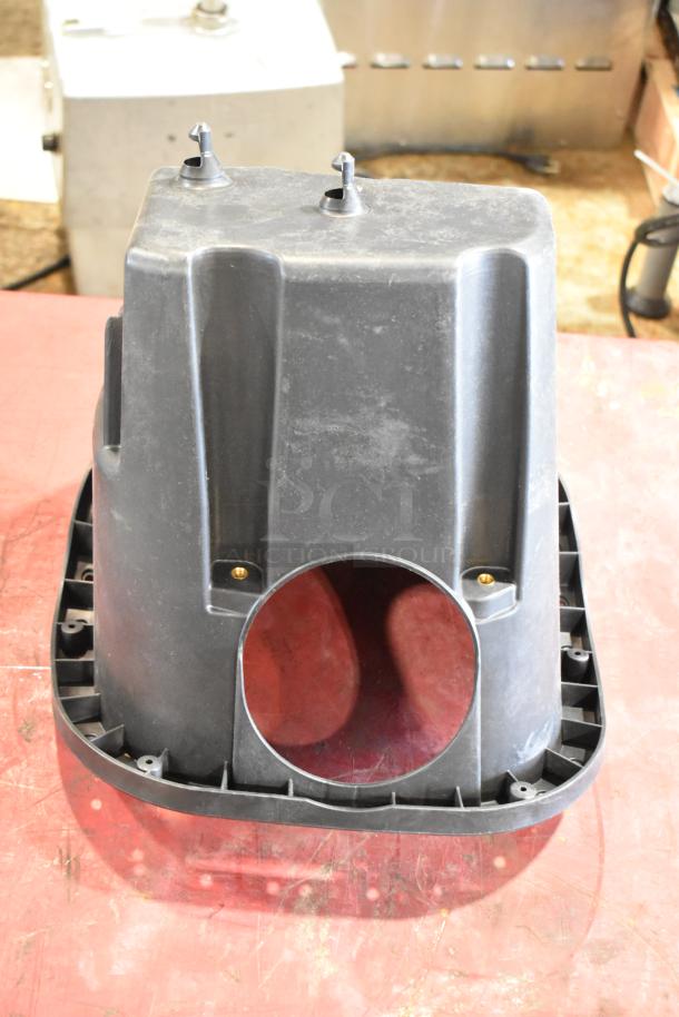 Box of parts with a large black plastic filter housing. Visible wear and mounting points. No visible labels or markings.