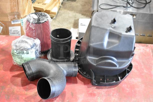 Box of parts with 1115TT-CAKHWKB-AA cold air intake kit, new condition, includes filter and intake components.