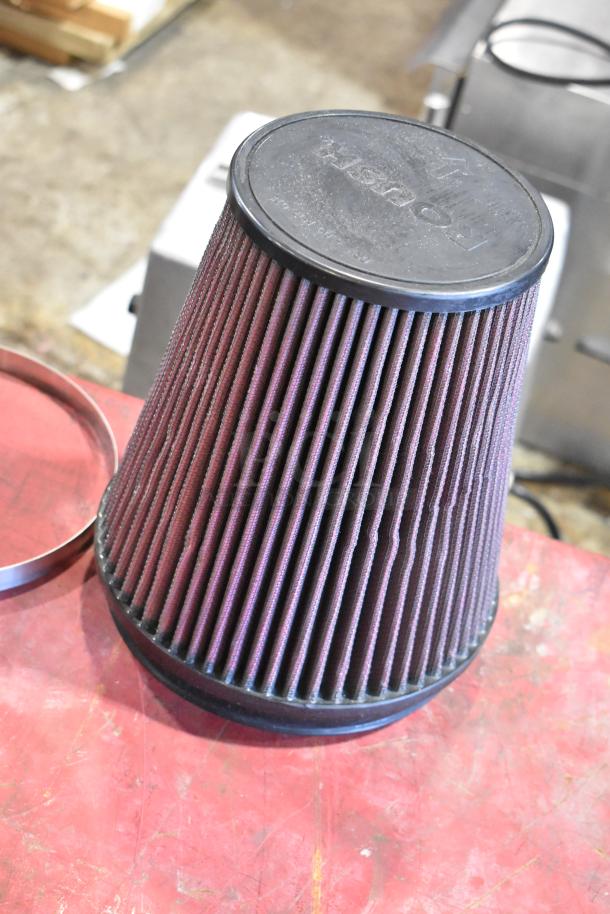 Box containing a cold air intake kit filter with visible branding on the lid; parts appear in used condition.