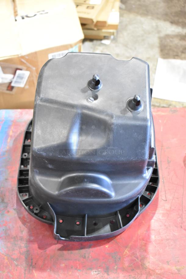 Box of parts including a black cold air intake kit component on a workshop table, showing two visible connectors.