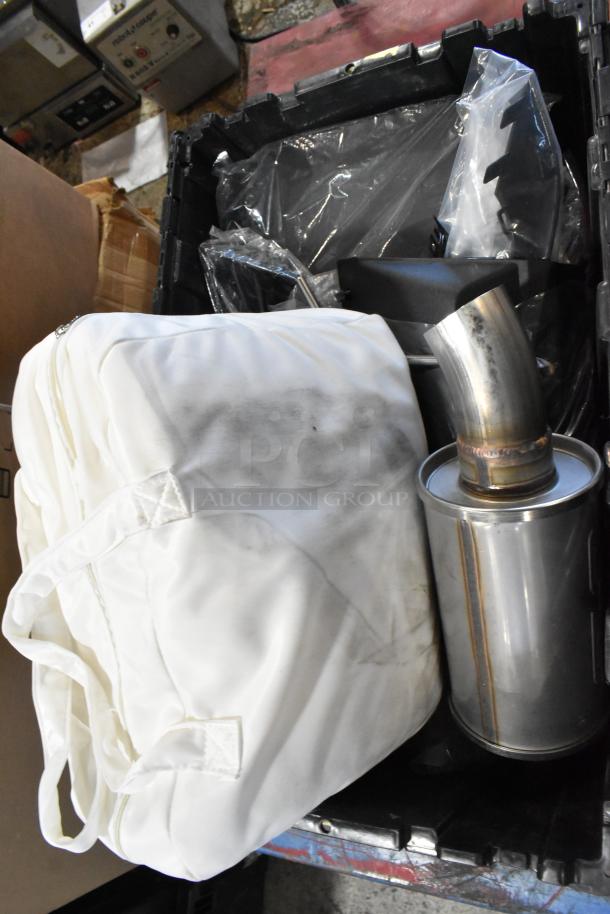 Box of assorted parts including an exhaust section in a black poly bin. Items appear in used condition.