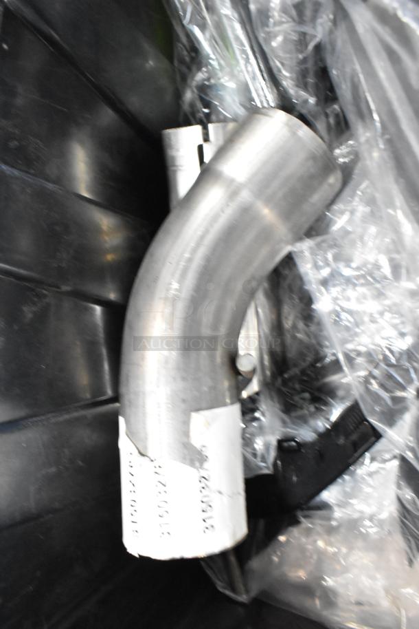 Box of parts in black poly bin, includes metal exhaust components, visible labels with numbers, wrapped in plastic, good condition.