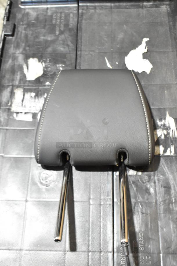 Box with headrest inside, black poly bin, headrest in good condition, black leather with chrome stems, visible stitching.