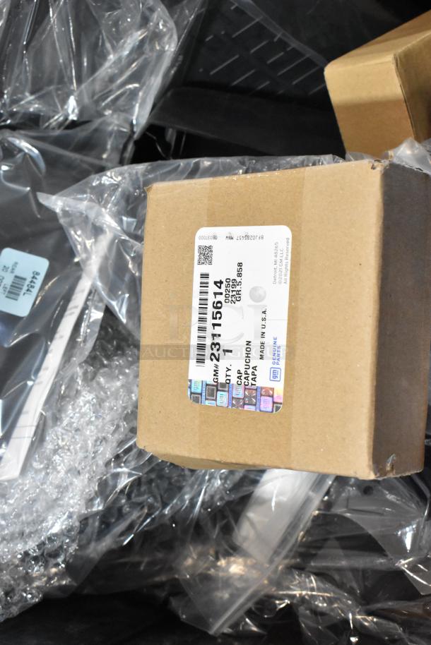 Box of various parts, including labeled GMC panels, in a black poly bin. Brown box shows GM part label: 23115014.