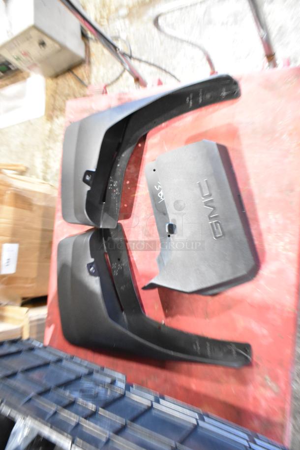Box of GMC panels in black poly bin, includes two large curvy panels and a flat piece with "GMC" text, in good condition.