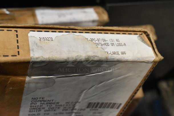 Cardboard box with shipping label, partially visible text including item codes and order details. Box shows slight wear.