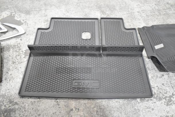 GMC car floor mats, black, textured design, set of 24. New condition, enhances interior protection.