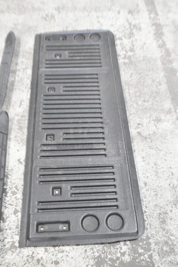 Black car floor mat with textured grooves; includes mounting holes. Appears in good condition, suitable for various vehicles.