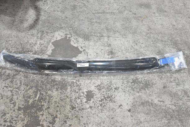 Sealed car floor mat in plastic packaging, labeled with barcode and item details, on a concrete floor.