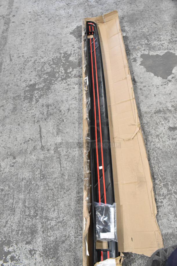Boxed item with long black and red component, possible vehicle part, in cardboard packaging. Condition appears new.
