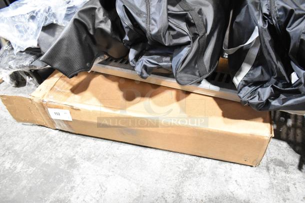 Cardboard box containing car floor mats, showing minor wear. Includes label with quantity "152."
