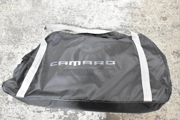 Black Camaro-branded bag from a lot of various items, featuring white handles. Appears in good condition.
