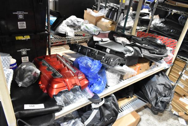 Tiered lot of various automotive parts, including Corvette engine cover and 111550-CAKHWK-AA Kit, on storage shelves.