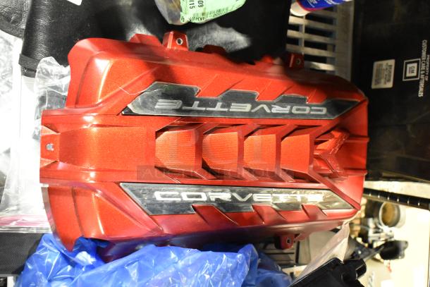 Red Corvette engine cover with chrome lettering, part of auction lot. Item code 111550-CAKHWK-AA. Appears in good condition.