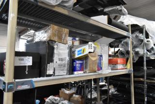 Tiered shelf with various items including printer paper, car parts, ACDelco box, filters. Boxes and labels visible.