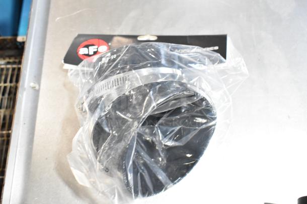 AFe car part in original packaging, shown on a table. Item is part of a mixed item auction lot including printer paper.
