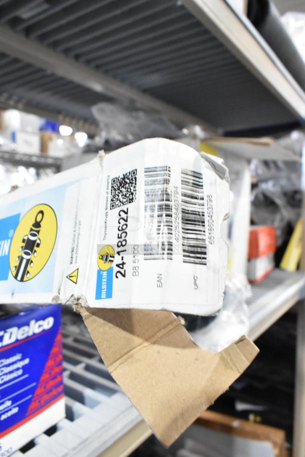 Lot including various items like Bilstein car parts, with visible box markings "24-185622" and "B8 5100," stored on a shelf.