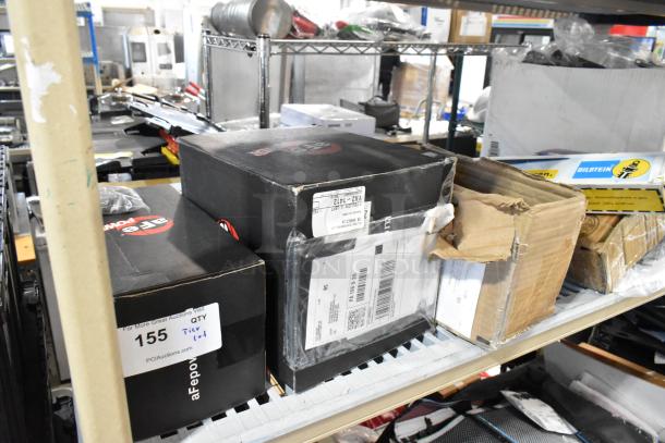 Shelf with tier lot items: boxes of car parts, printer paper, visible Bilstein label, assorted condition, auction tag 155.