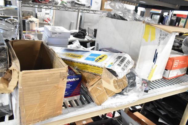 Tier lot of mixed items including printer paper, Bilstein car parts, ACDelco filters; visible wear on boxes.