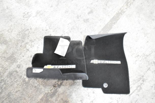 Alt text: "Lot of Chevrolet Tahoe black floor mats, new condition, with Tahoe logo, part of a mixed items auction."