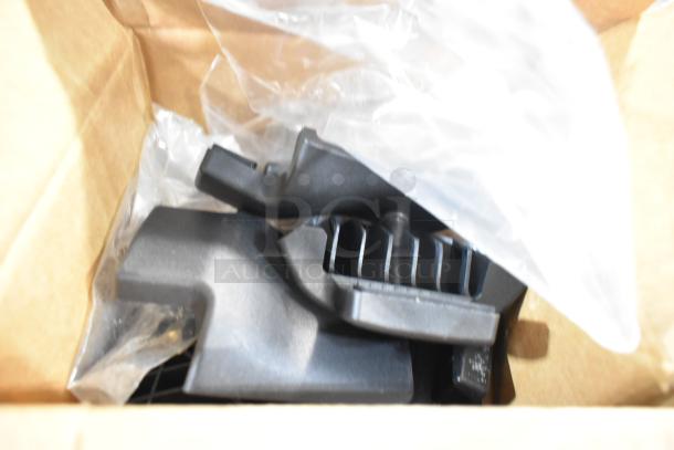 Box containing various black car parts and floor mats, wrapped in plastic, condition appears new.