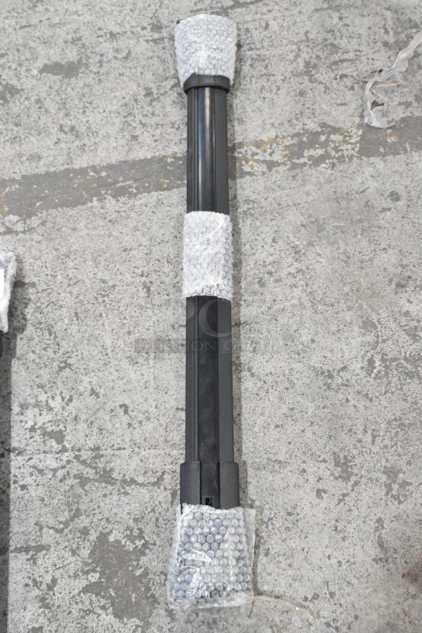 Two black metal items wrapped in bubble wrap, showcasing sturdy construction and meant for auction; condition appears new.