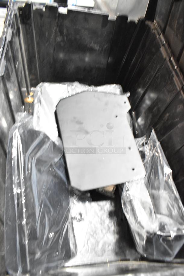 Black poly bin containing various items, including GMC parts. Bin is used, showing interior view with plastic-wrapped contents.