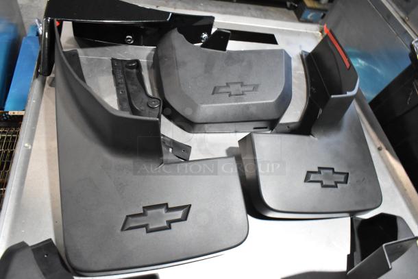 Lot of various Chevy panels in black poly bin, featuring multiple black covers with Chevy logos, in good condition.