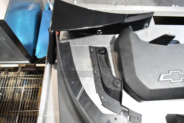 Lot of various items including Chevy panels in a black poly bin. Features Chevrolet logo, parts in good condition.