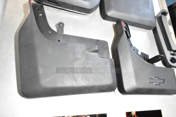 Lot of various GMC panels in black, featuring embossed Chevrolet logo, in a black poly bin. Components mostly intact.