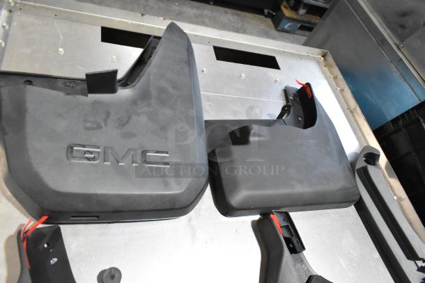 Lot of automotive parts including GMC panels in a black poly bin, featuring visible "GMC" branding.