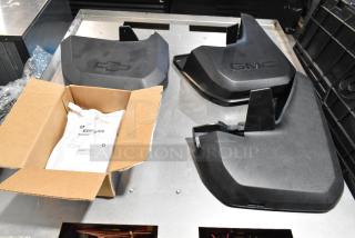 Lot of various items in black poly bin with GMC panels, including a Chevrolet panel. Items appear lightly used.