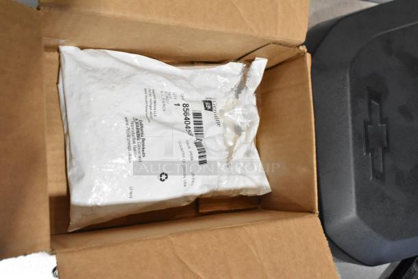 Lot of various items, including GMC panels, in black poly bin. White packaging labeled "Genuine GM Parts" with visible barcode and text.