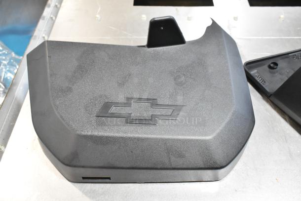 Black GMC panel with embossed Chevrolet logo, in good condition. Part of a mixed lot in a black poly bin.