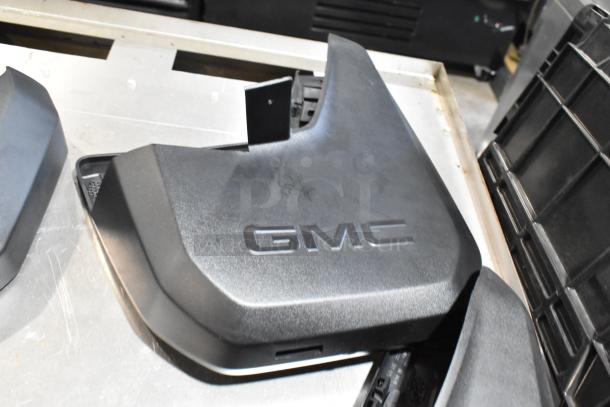 Black GMC panel in a poly bin, lightly used, with clear GMC branding. Part of a larger mixed item lot.