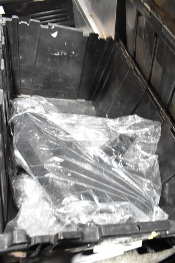Black poly bin containing various items including GMC panels, wrapped in plastic, in used condition.