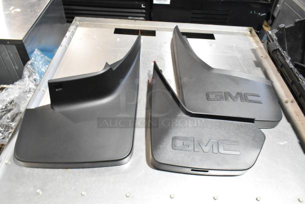 Lot of GMC black panels in a poly bin, featuring sleek design, good condition, with embossed GMC logo.