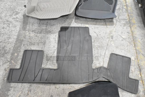 Various car floor mats in black and gray, used condition, with textured surfaces, part of a mixed auction lot.